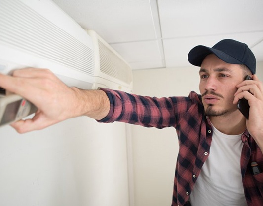 a technician holding up a dirty air filter