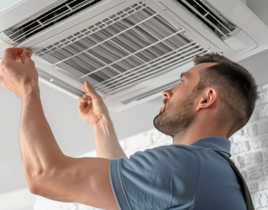 a technician giving a thumbs-up next to an HVAC unit