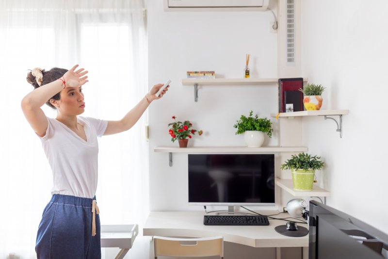 a woman changing the temperature in her house